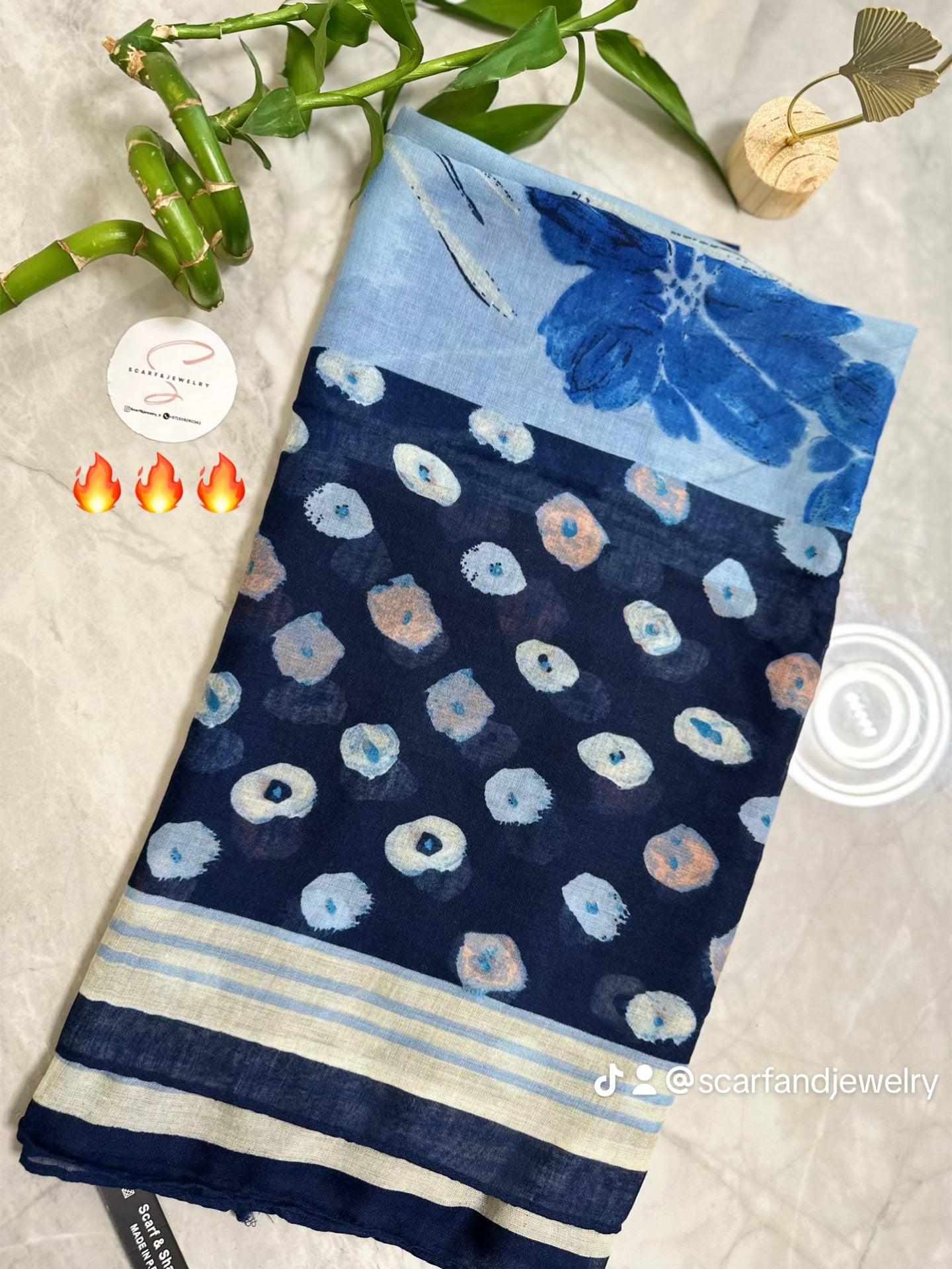 Blue and white patterned fabric with a bamboo plant on a light background